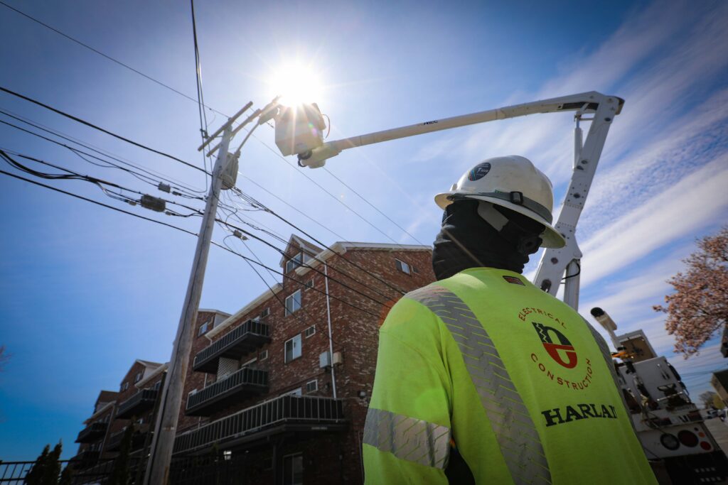 MYR team member observing teammate perform maintenance on power line