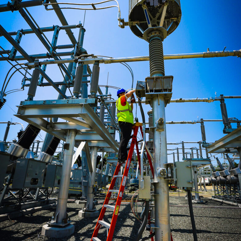 Man on ladder working in a substation