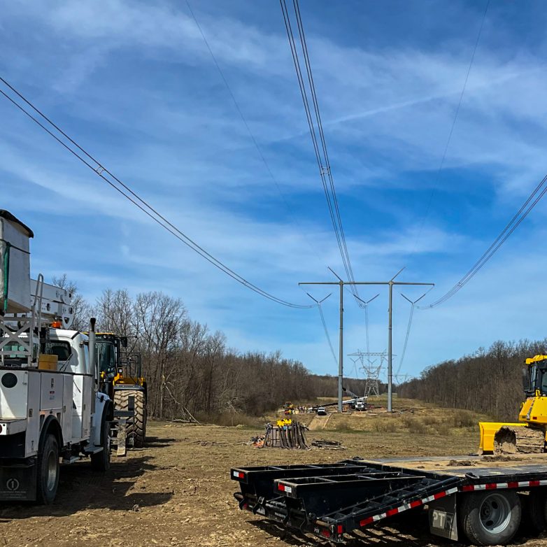 A 765kV transmission line and lattice tower restored after a storm.